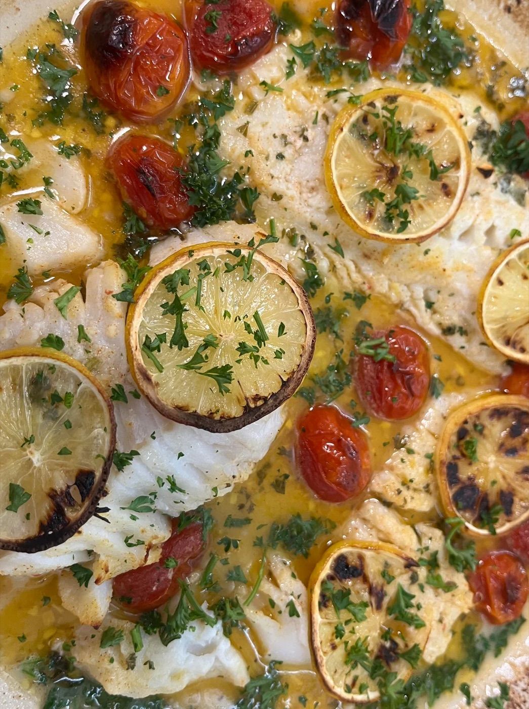 White fish roasted with charred lemon, cherry tomatoes and herbs